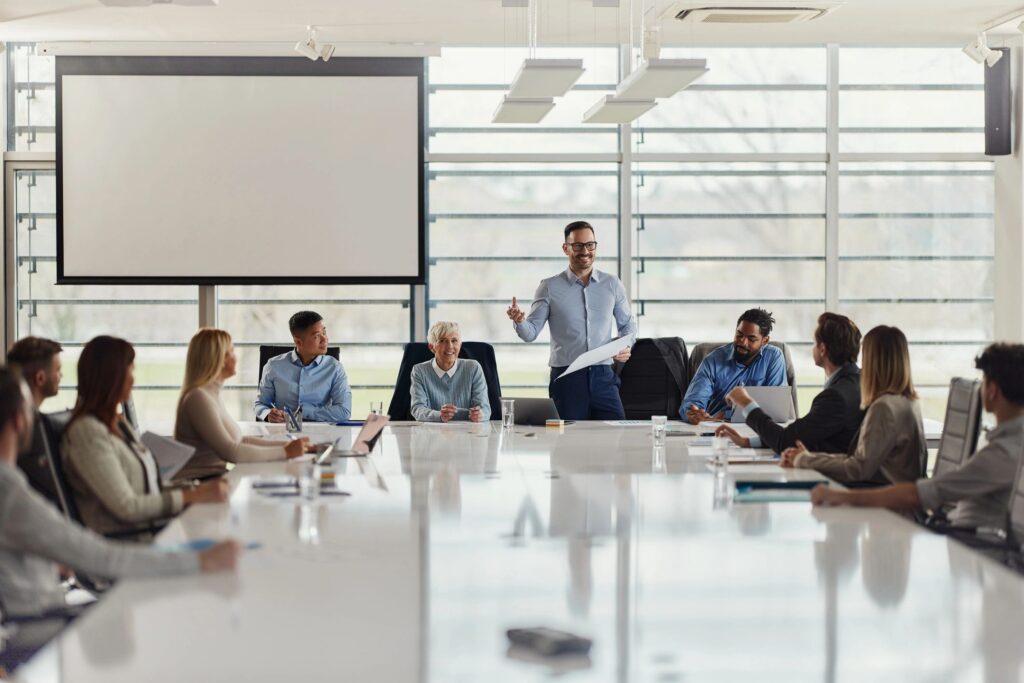 Happy businessman giving a speech on a meeting in conference room.