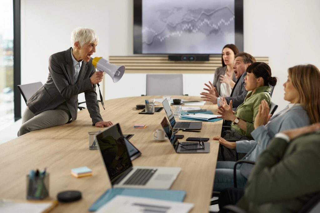 Angry senior CEO bullying her colleagues on a meeting.