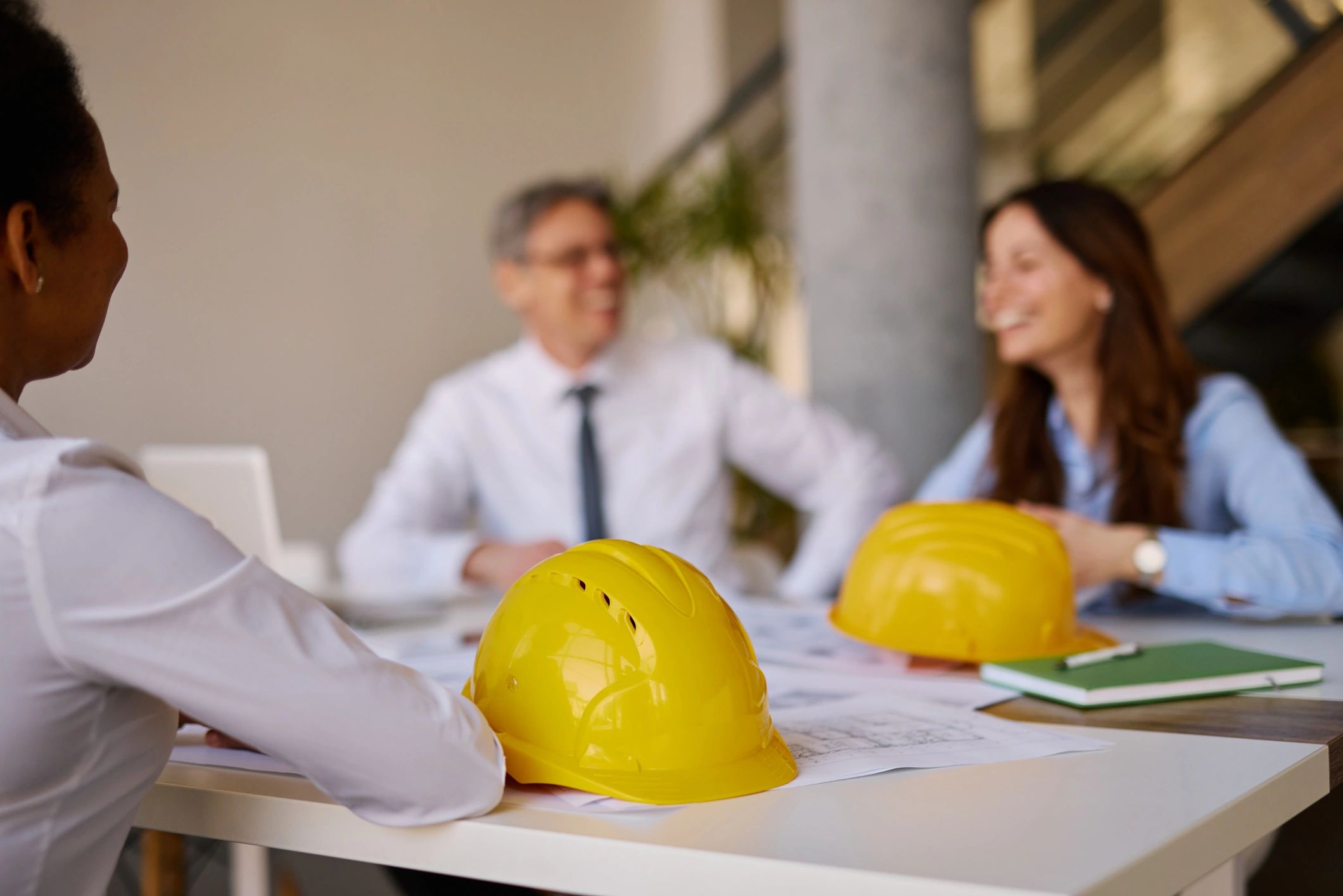 Safety helmets and plans on a table during a planning meeting